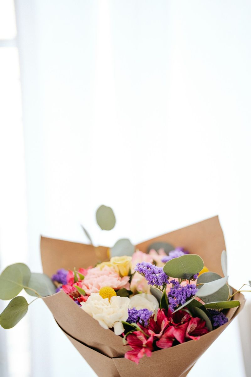 Wrapped bouquet of seasonal flowers on a florist workbench