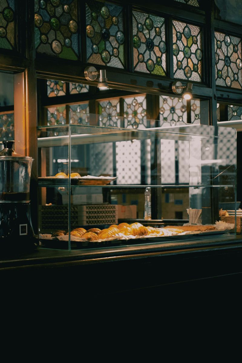 Sourdough loaf and croissants on a wooden counter in an artisan bakery